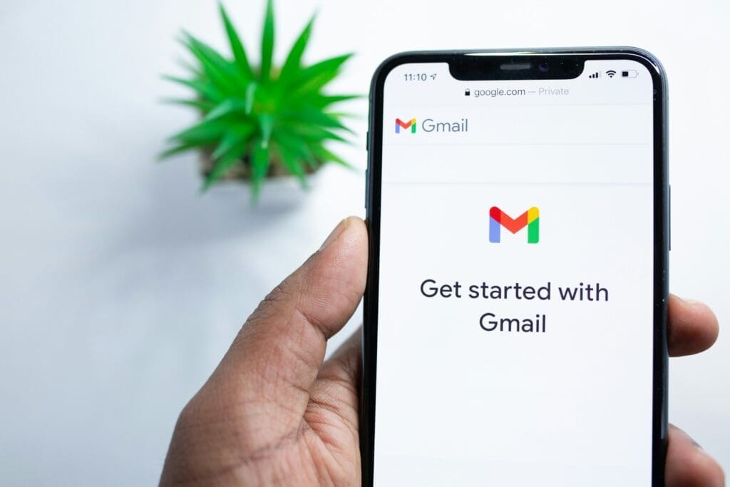 Man met telefoon met gmail-scherm